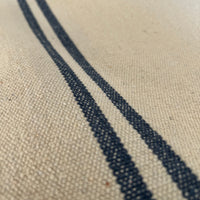 Close-up of a textured fabric with blue stripe on a neutral background